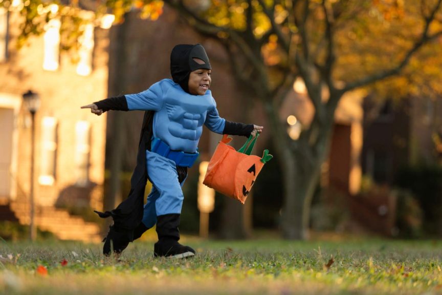 Boy running in superhero costume halloween