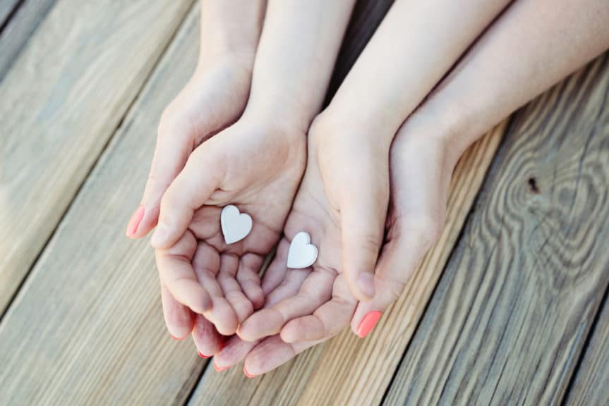 Child and mother holding heart in hands