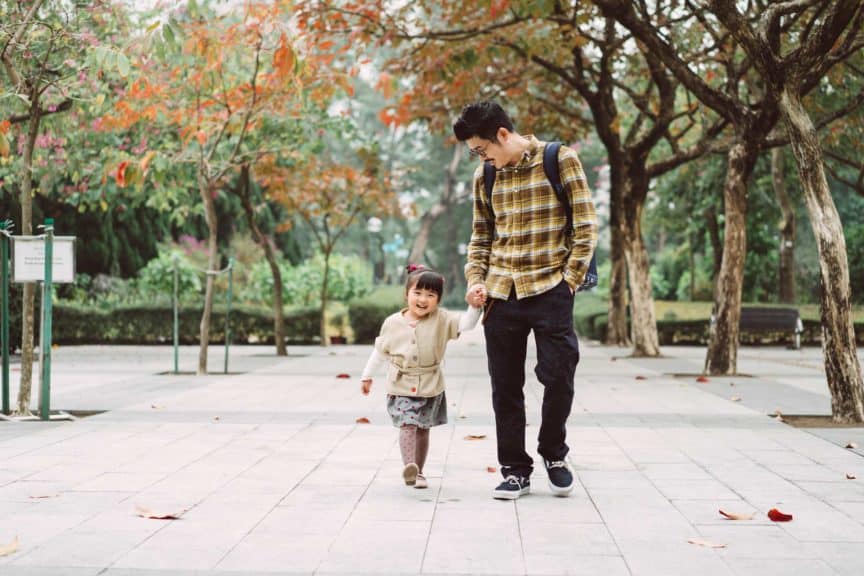 Dad and daughter strolling in park joyfully