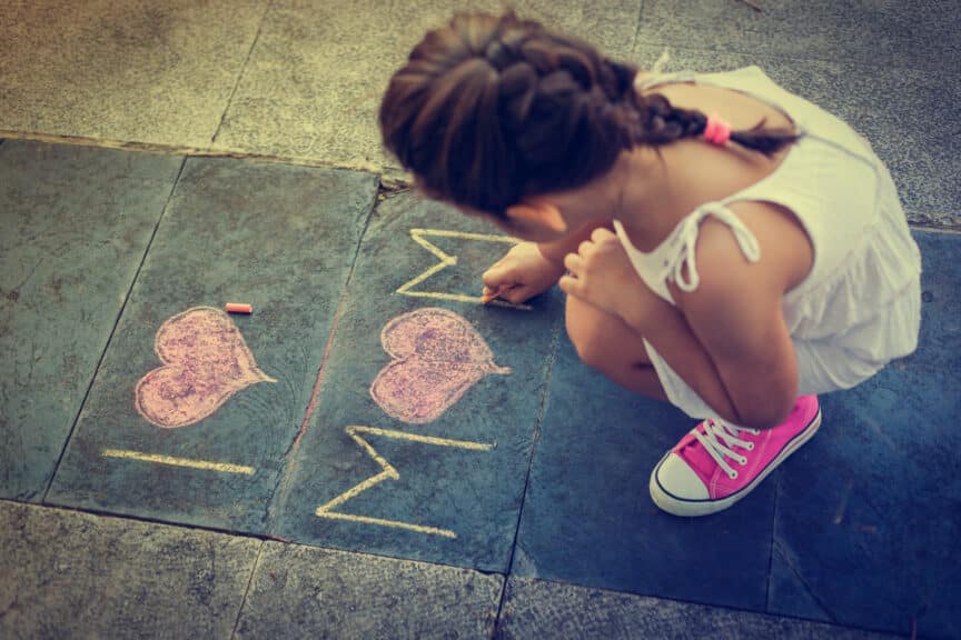 girl writing i love mom with chalk