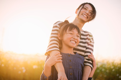Mother and daughter smiling in a field