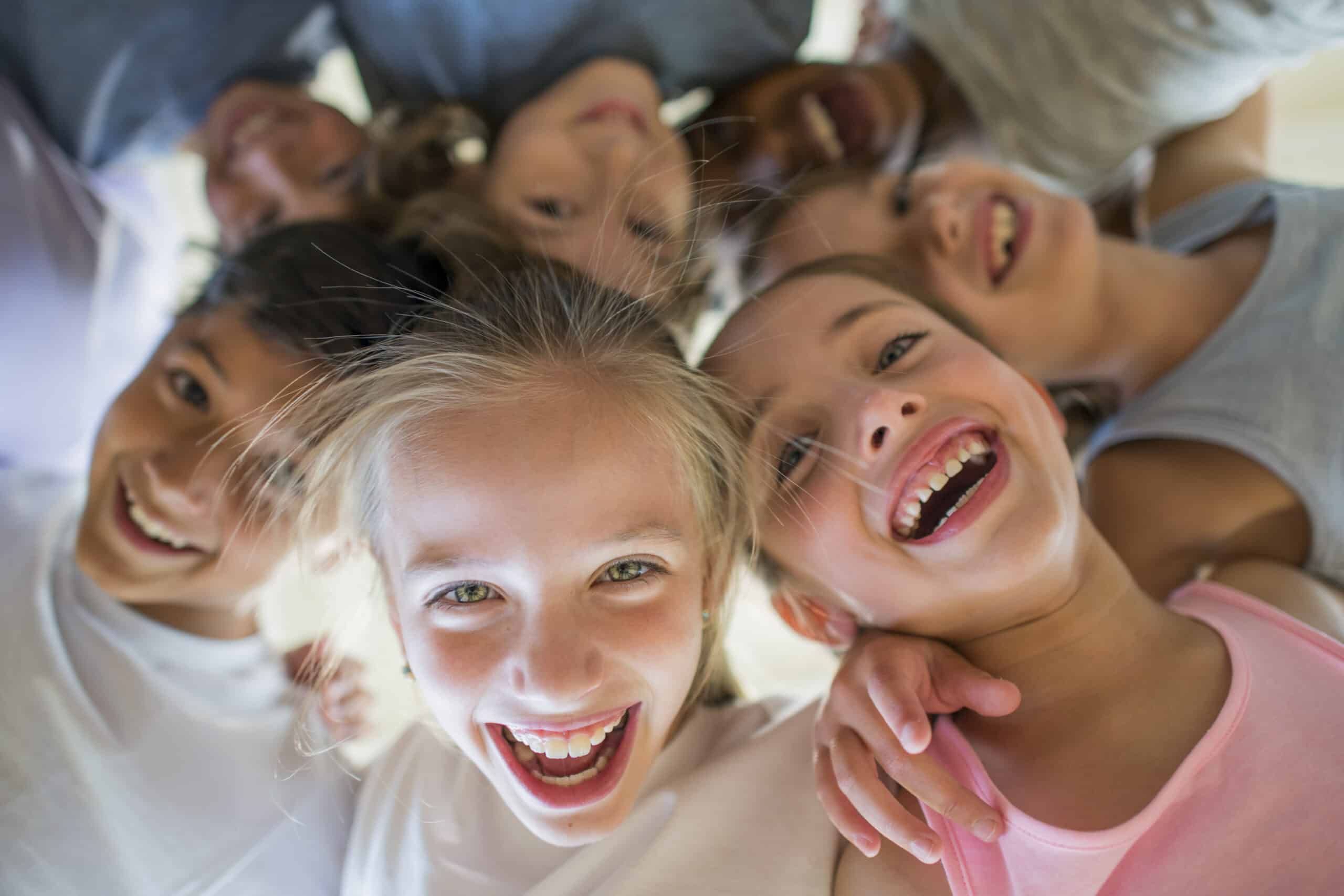 laughing children standing in a circle over the camera