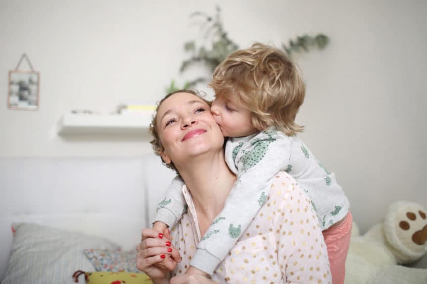 mother being kissed by child at home