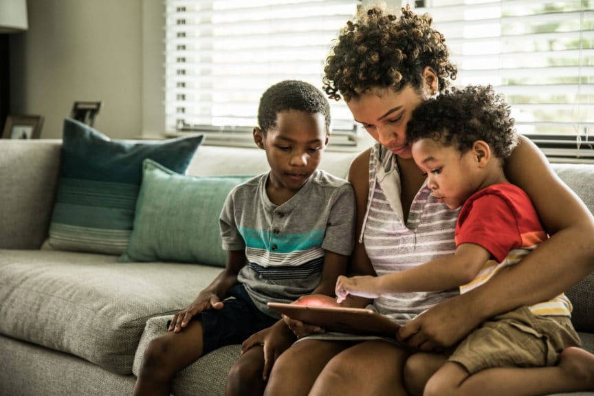Mother using tablet with kids at home