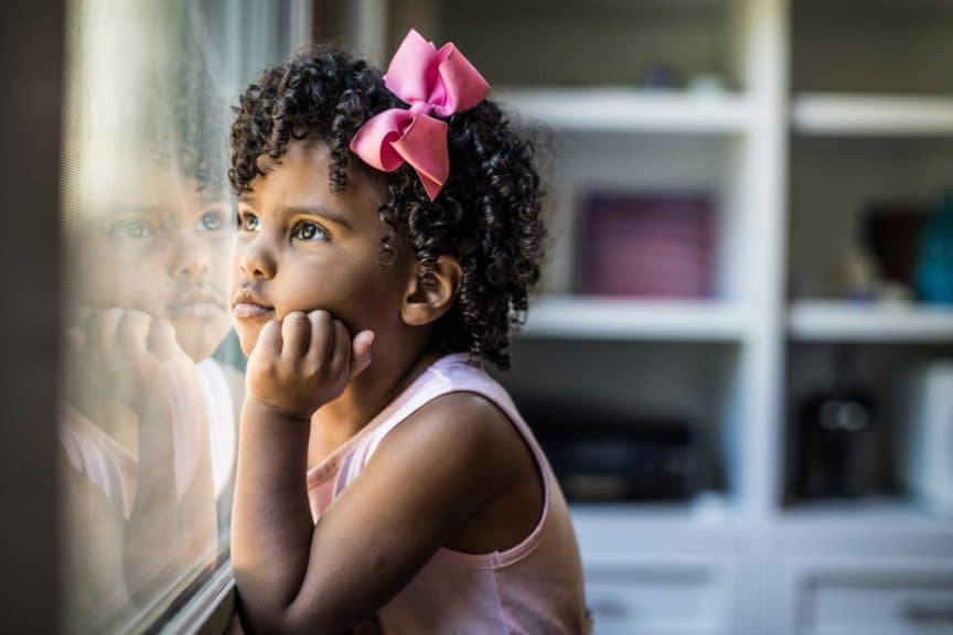 Portrait of preschool age girl looking out window