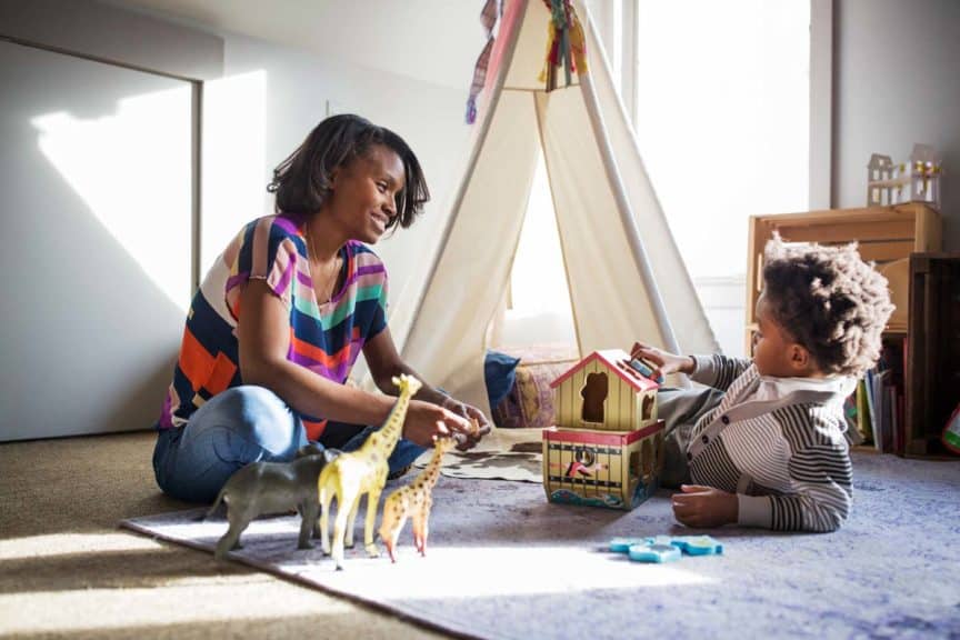 smiling-woman-looking-son-toys-bedroom