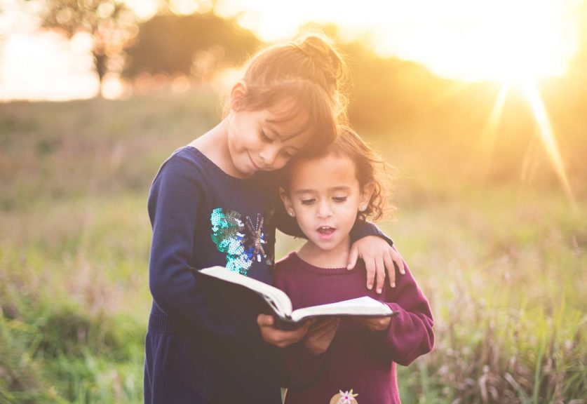 Girls reading outside with sunset