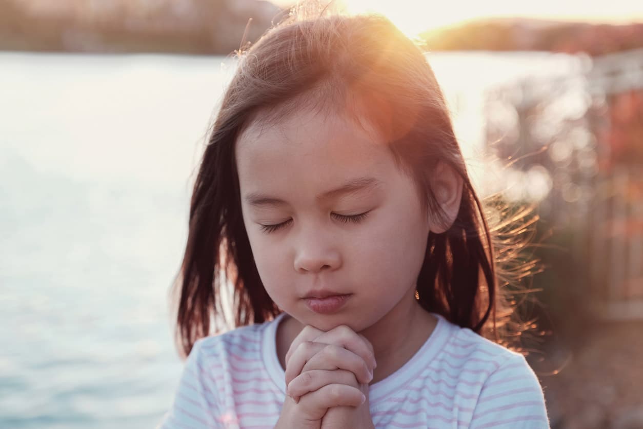 Young girl prays.